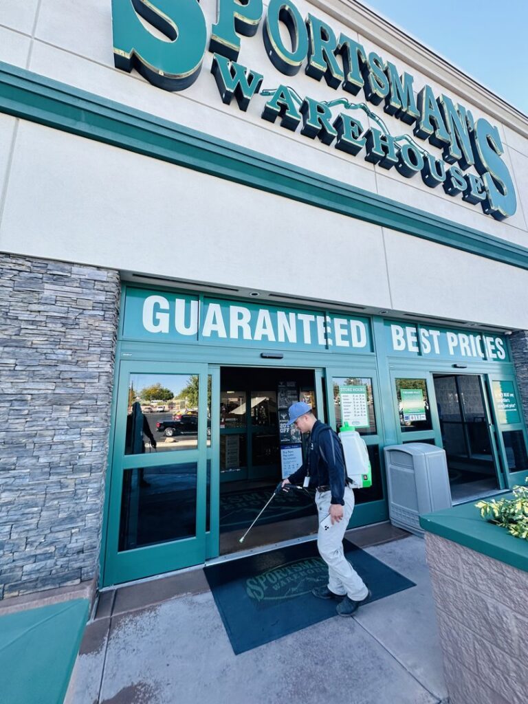 A Box Pest Control technician performing commercial pest control service at a Sportsman's Warehouse in Farmington, NM.