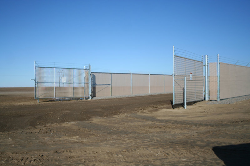 A commercial fence with privacy slats and double gates, installed by Life Time Fence, Inc. in Cedar Rapids, IA.