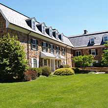 A large commercial property with a neatly manicured lawn and shrubs, maintained by Ground Effects Lawn Care in St. Louis, MO.