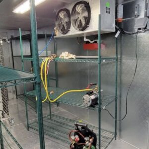 Commercial refrigeration unit being serviced with gauges and tools by JM HVAC Pros in Elgin, IL.