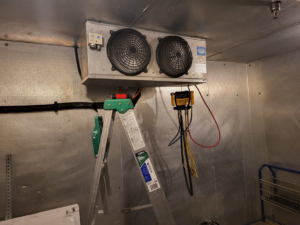 A commercial refrigeration unit being serviced with gauges connected by Santos Heating and Cooling in St Joseph, MO.