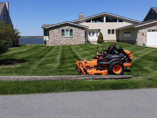 A commercial riding lawn mower parked on a perfectly striped lawn by John's Lawn Care Service's in Saint Petersburg, FL
