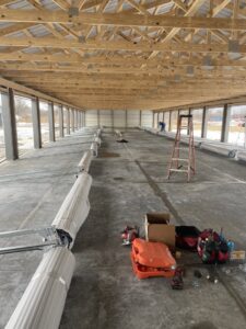 Roll-up garage door components laid out for installation inside a large commercial building by Garage Door Repair Company, LLC in Pueblo, CO.