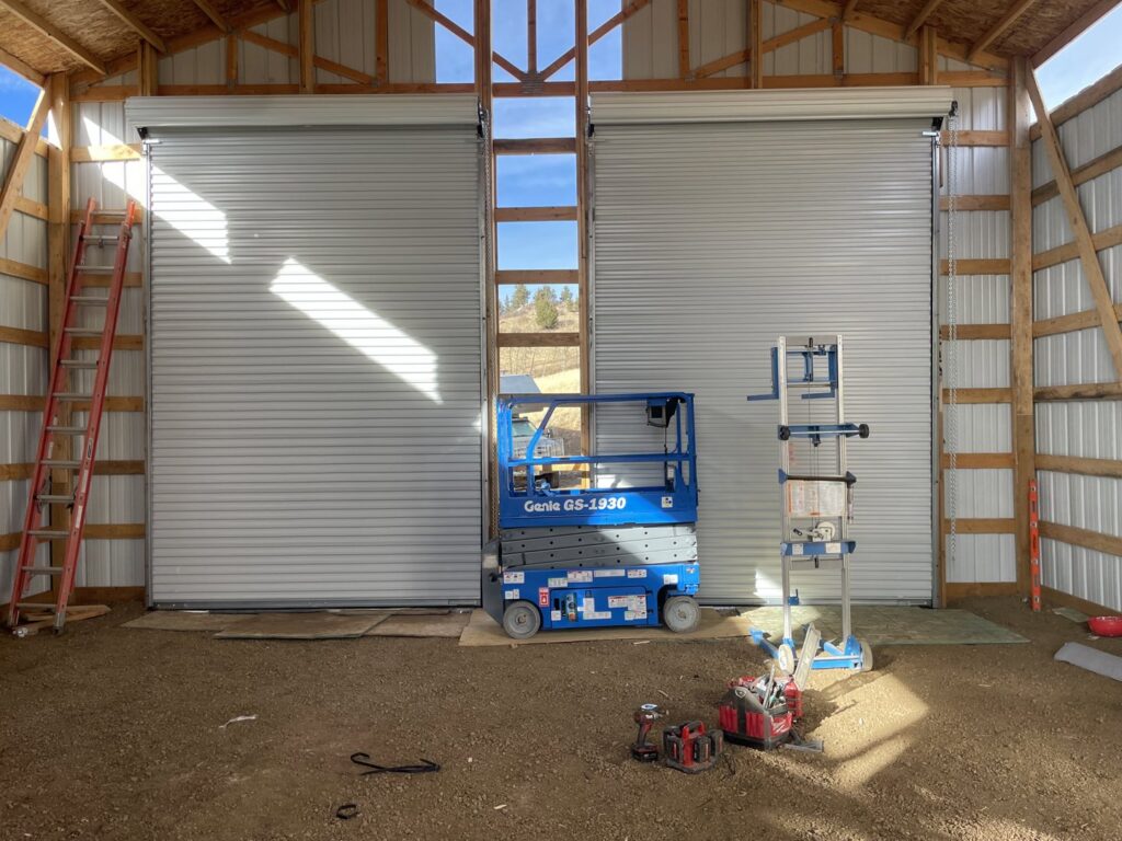 Installation of large commercial roll-up garage doors at a construction site by Garage Door Repair Company, LLC in Pueblo, CO.