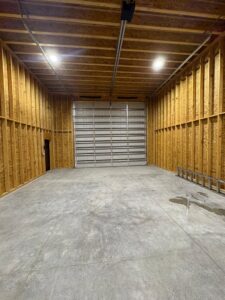 A newly installed commercial roll-up garage door in a spacious garage by Lenny's Garage Door in Louisville, KY.