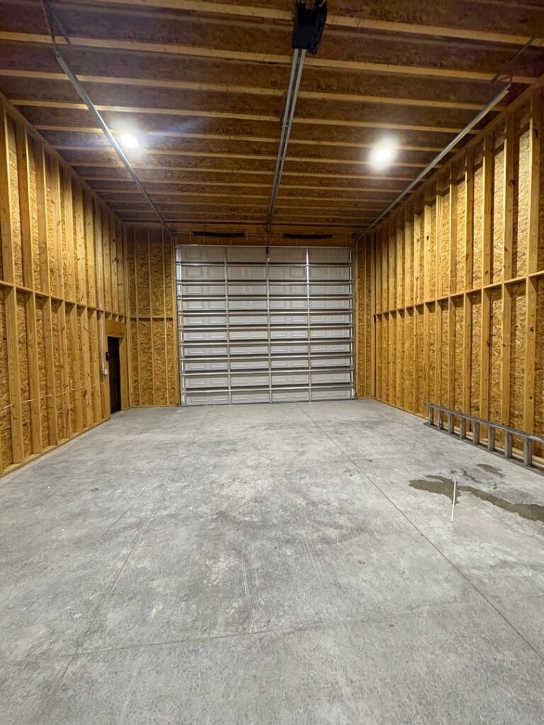 A newly installed commercial roll-up garage door in a spacious garage by Lenny's Garage Door in Louisville, KY.
