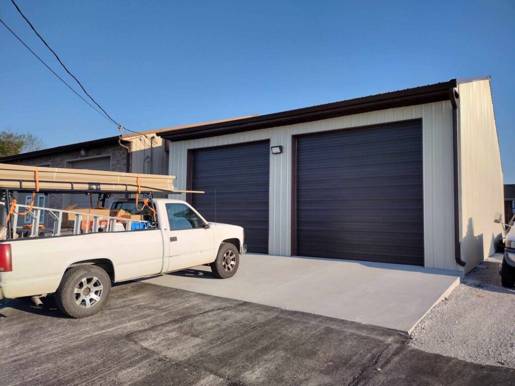 Two dark brown commercial roll-up garage doors installed on a metal building by Honest Overhead Garage Doors in Elizabethtown, KY.