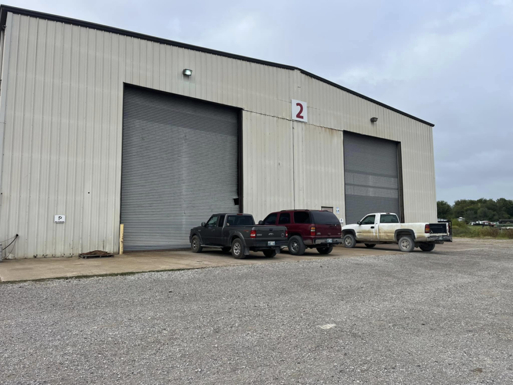 Large commercial roll-up garage doors on an industrial building serviced by Horton & Hill Garage Door Specialists LLC in Sapulpa, OK.