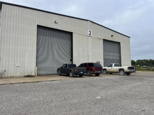 Large commercial roll-up garage doors on an industrial building serviced by Horton & Hill Garage Door Specialists LLC in Sapulpa, OK.