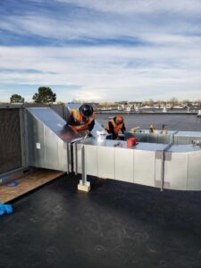 Technicians installing commercial rooftop ductwork for Advanced Comfort Solutions, Inc. in Cheyenne, WY.