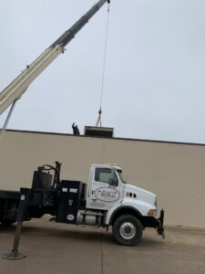 A crane lifting a new HVAC unit onto a commercial rooftop for installation by Epic Heating & Cooling in Wichita, KS.