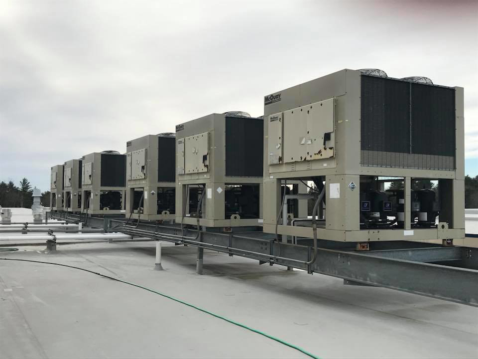 A row of commercial rooftop HVAC units installed by RTH Mechanical Contractors in Dover, NH.