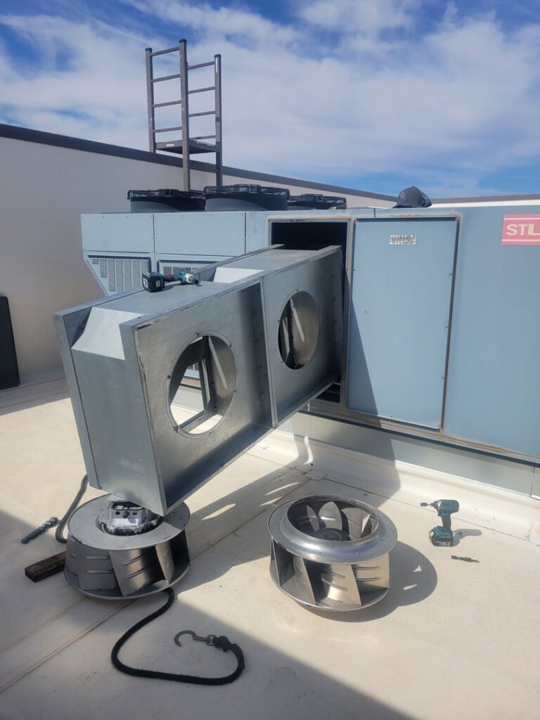 A commercial rooftop HVAC unit undergoing repair with internal blower components removed by Az AC and Heat Services in Queen Creek, AZ.
