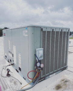 Servicing a commercial rooftop HVAC unit with gauges and tools by A & A Air Conditioning & Heating in Little Rock, AR.