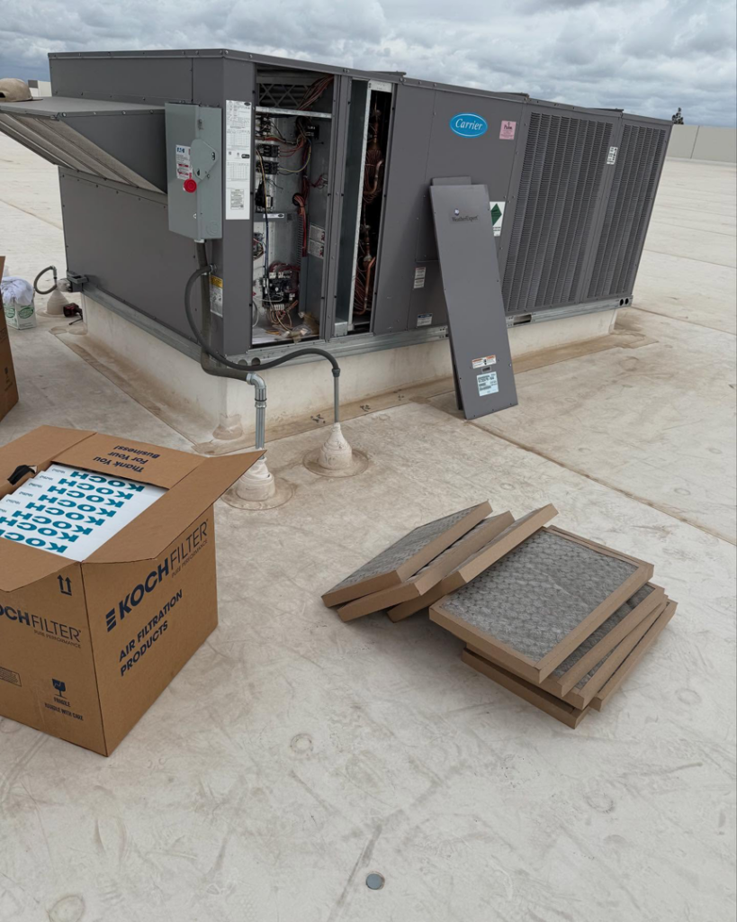 A commercial rooftop HVAC unit undergoing service with new air filters ready for replacement by Otto's Air Conditioning & Heating in Mesa, AZ.