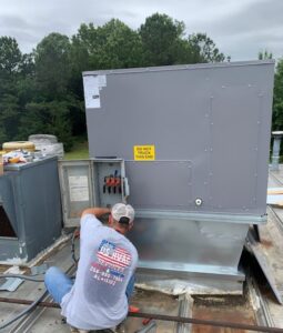A U.S. HVAC Services, LLC technician performing maintenance on a commercial rooftop HVAC unit in Madison, AL.