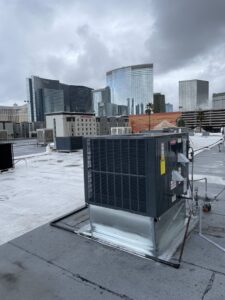 A commercial rooftop HVAC unit with a city skyline in the background, serviced by Allstar Heating & Cooling in Port Richey, FL