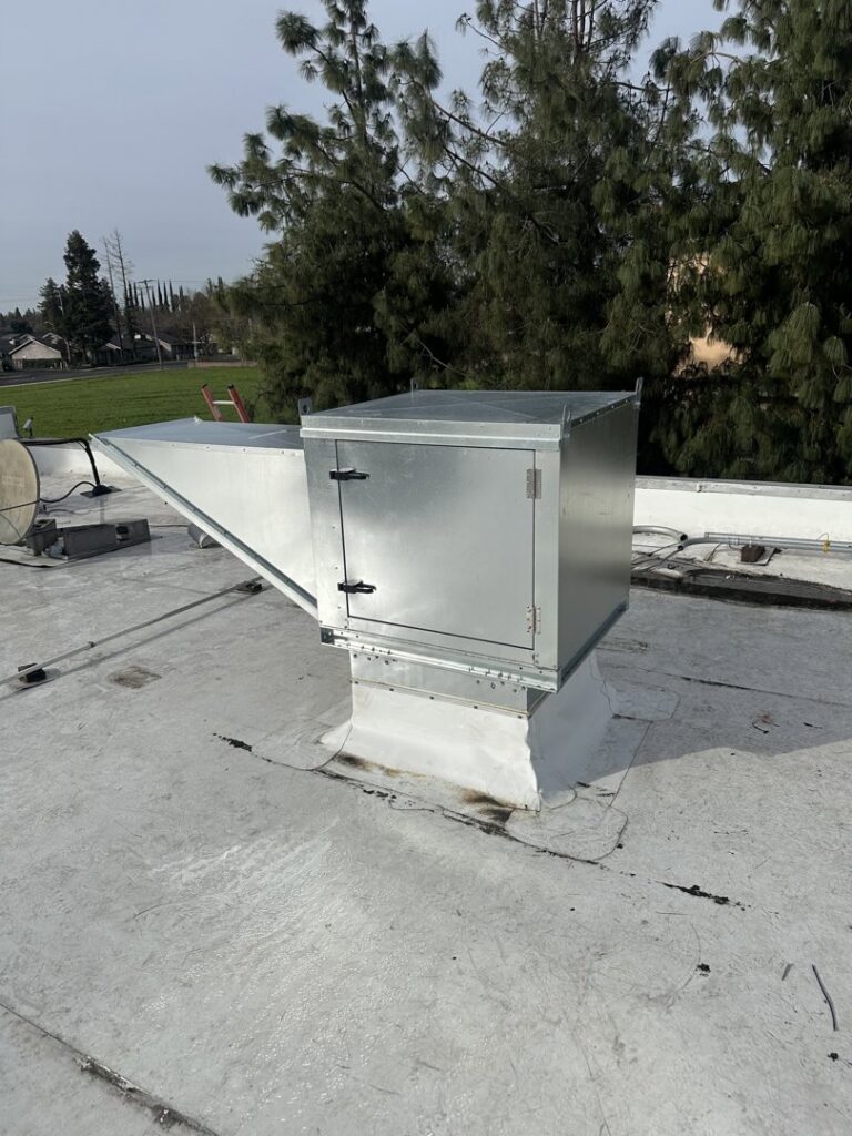 A commercial rooftop HVAC unit and ductwork on a building by DeHart Plumbing, Heating, & Air in Sparks, NV.