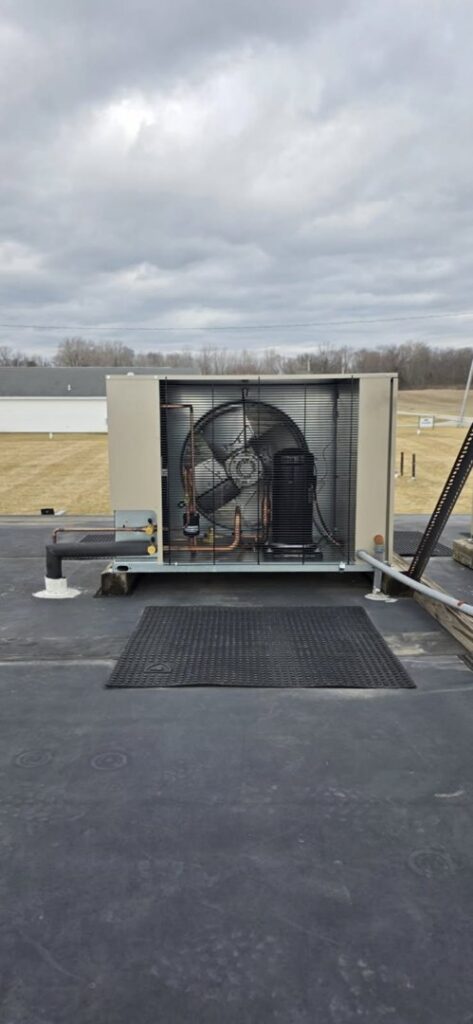 A commercial rooftop HVAC unit showing the fan and internal components by Pike Mechanical in Vevay, IN.