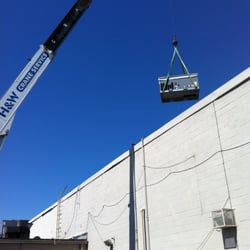 A crane lifting a new commercial rooftop HVAC unit into place during an installation by 495 HVAC in Annandale, VA.