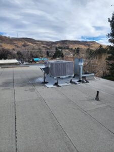 A commercial rooftop HVAC unit installation with a view of the surrounding area by D & D Heating & Air in Brighton, CO.