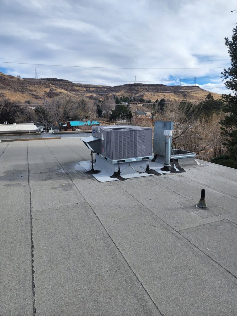 A commercial rooftop HVAC unit installation with a view of the surrounding area by D & D Heating & Air in Brighton, CO.