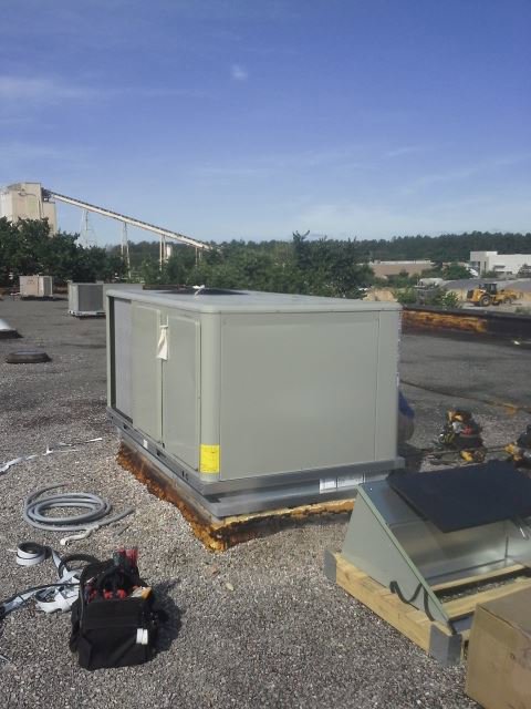 A large commercial rooftop HVAC unit installation with tools nearby by ReDesign Air in Winchester, VA.