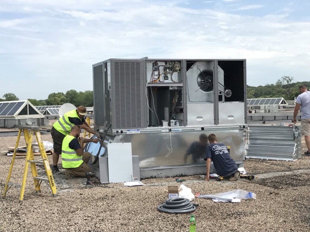 R.J. Nelson Co technicians installing a large commercial rooftop HVAC unit in Council Bluffs, IA.