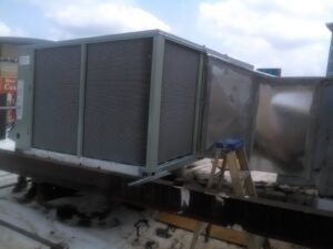 A large commercial rooftop HVAC unit with ductwork, undergoing installation or service by West Tennessee Heat & Air in Memphis, TN