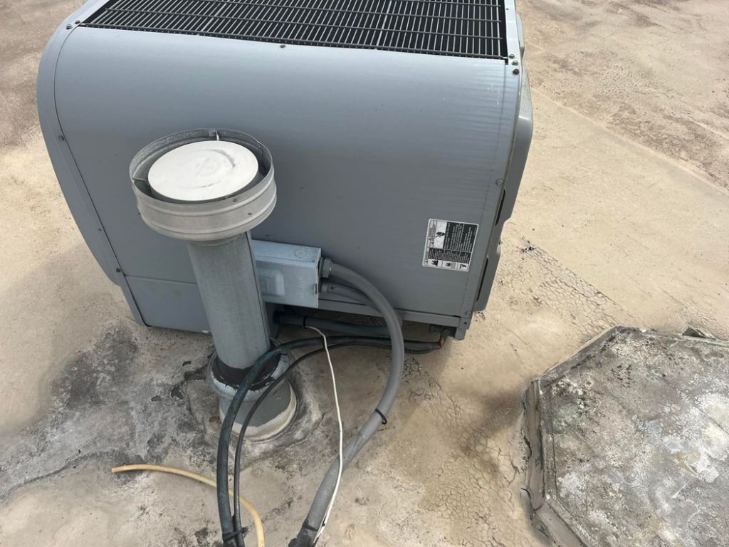 A large commercial rooftop HVAC unit with connected piping and electrical lines, serviced by KATS Heating & Cooling in La Grange Park, IL.