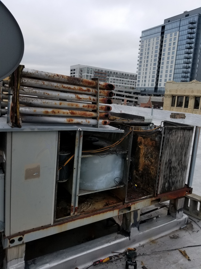 A large, rusted commercial rooftop HVAC unit undergoing repair or maintenance by ARC Mechanical Inc in South Elgin, IL.