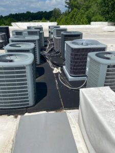 Multiple commercial rooftop HVAC condenser units serviced by All American Heating Air & More LLC in Wilson, NC.