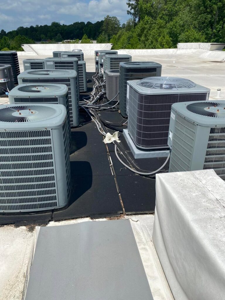 Multiple commercial rooftop HVAC condenser units serviced by All American Heating Air & More LLC in Wilson, NC.