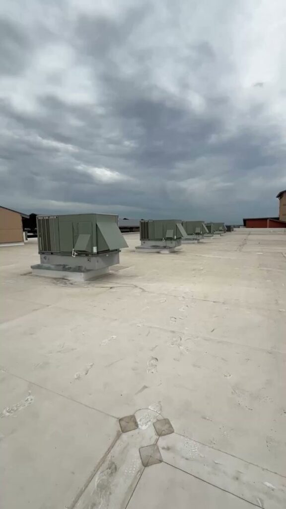 Multiple commercial rooftop HVAC units on a building serviced by Bree HVAC Contractor in Cedar Park, TX.