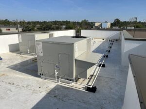 Two commercial rooftop HVAC units installed on a white roof by Huggins Mechanical in Jacksonville, FL