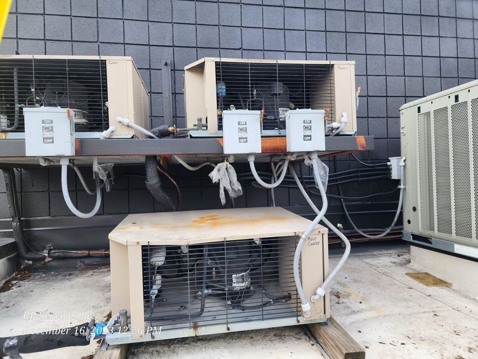 Multiple commercial rooftop HVAC units on a building, serviced by RP Services llc, heating & air conditioning in Louisville, KY.