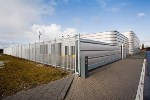 A robust commercial security fence with a large sliding gate protecting a facility, installed by Delmarva Facility Maintenance Services in Laurel, DE.