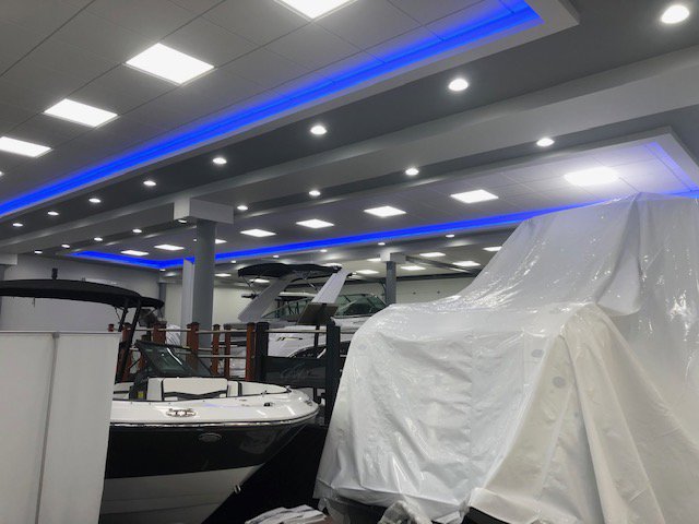 A commercial showroom interior showcasing modern ceiling lights and blue accent lighting by RTF Electric LLC in Toms River, NJ.