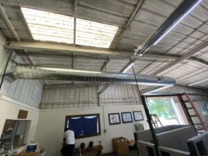 Large spiral ductwork being installed in a commercial building by Trinity Climate Control in Clayton, NC.