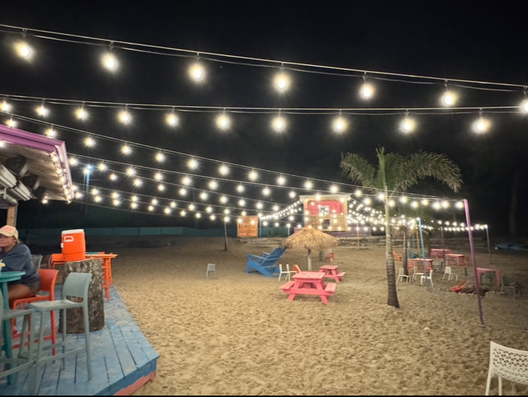 Overhead string lighting illuminating a commercial outdoor beach-themed bar by Get Lit KC & LOZ in Kansas City, KS.