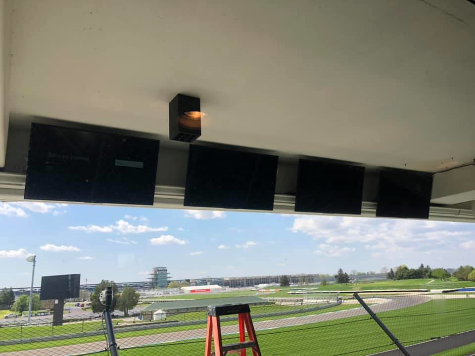 An electrician installing commercial televisions and wiring in a viewing suite at Dylco Electric in Westfield, IN