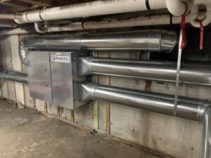 A commercial ventilation system with large metal ductwork and a RenewAire unit installed by Elite Mechanical in Manchester, NH.