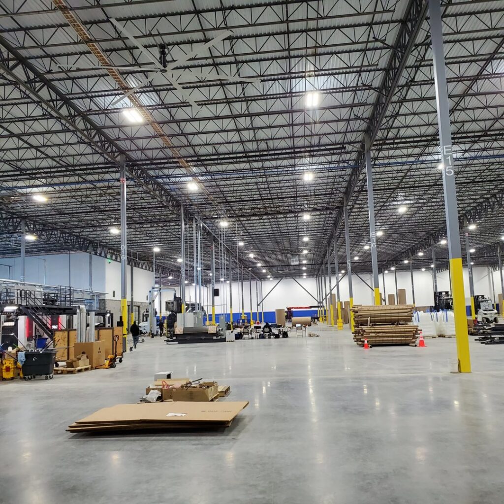 Interior view of a large commercial warehouse with industrial lighting, showcasing electrical installation by York Electrical Services in York, PA.