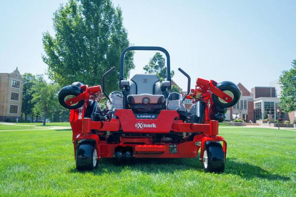 A red commercial zero-turn lawnmower on a green lawn, used by Tony's Lawn Care Services in Greenville, SC.