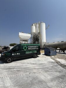 A Community Mechanical service van parked at an industrial site in Plano, TX.