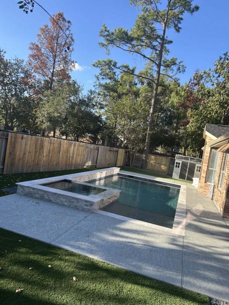 A compact backyard swimming pool with an attached spa by Top Tier Pools in Franklin, TN.