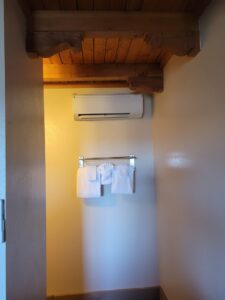 A compact mini-split air conditioning unit installed in a hallway by Pacheco Air Conditioning and Heating LLC in Albuquerque, NM.