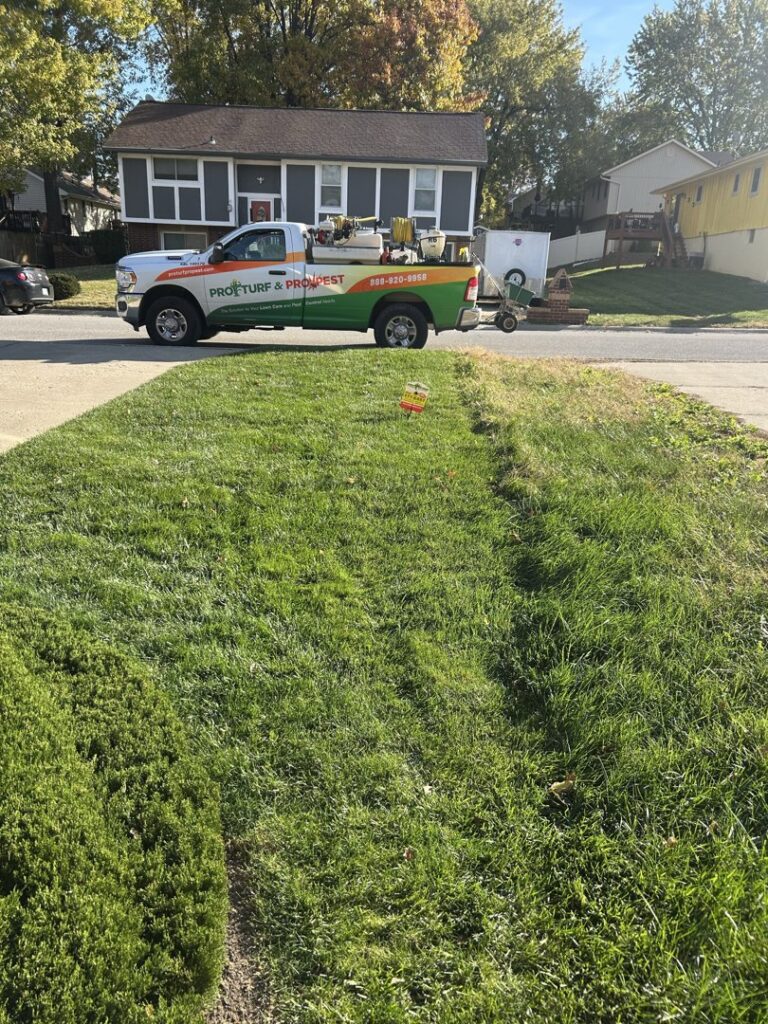 A Nebraska Pro Turf & Pro Pest Solutions company truck parked on a residential street next to a lawn with a service sign in Omaha, NE.