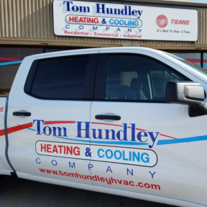 A branded company truck and building sign for Tom Hundley Heating & Cooling Company, LLC in Broken Arrow, OK.