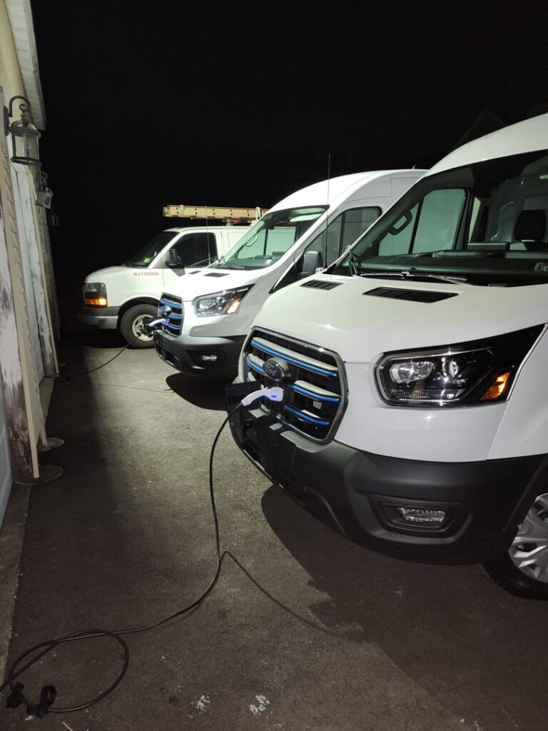 Henelect Electrical Contractors company vans charging at installed EV stations in Milford, NJ.